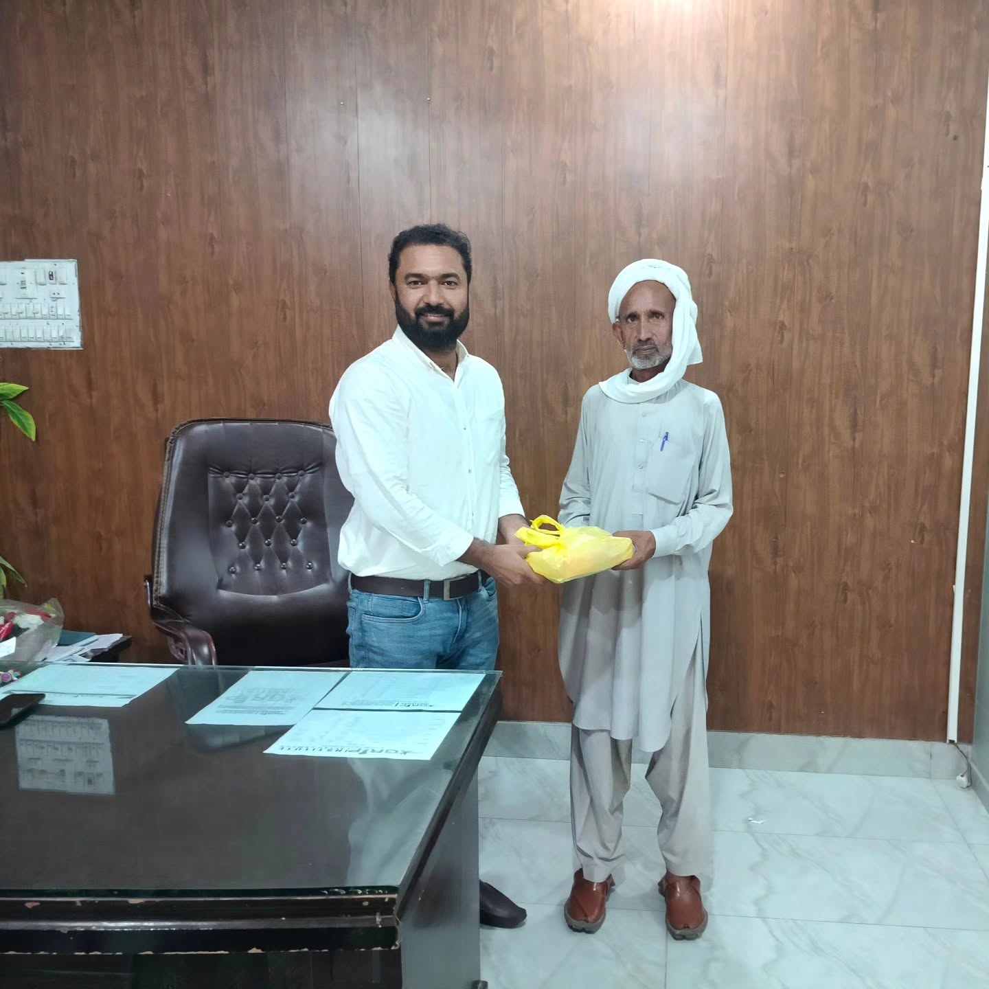 A Wisdom Institute coordinator handing a gift to a member of the community